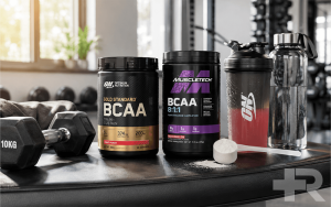 مکمل BCAA در کنار شیکر، آب و تجهیزات تمرینی